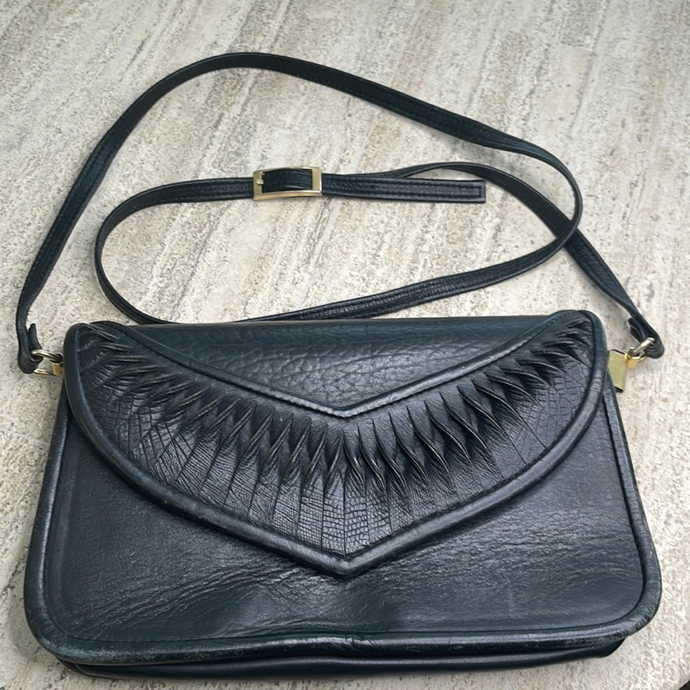VTG black leather crossbody bag with intricate leather details on flap.